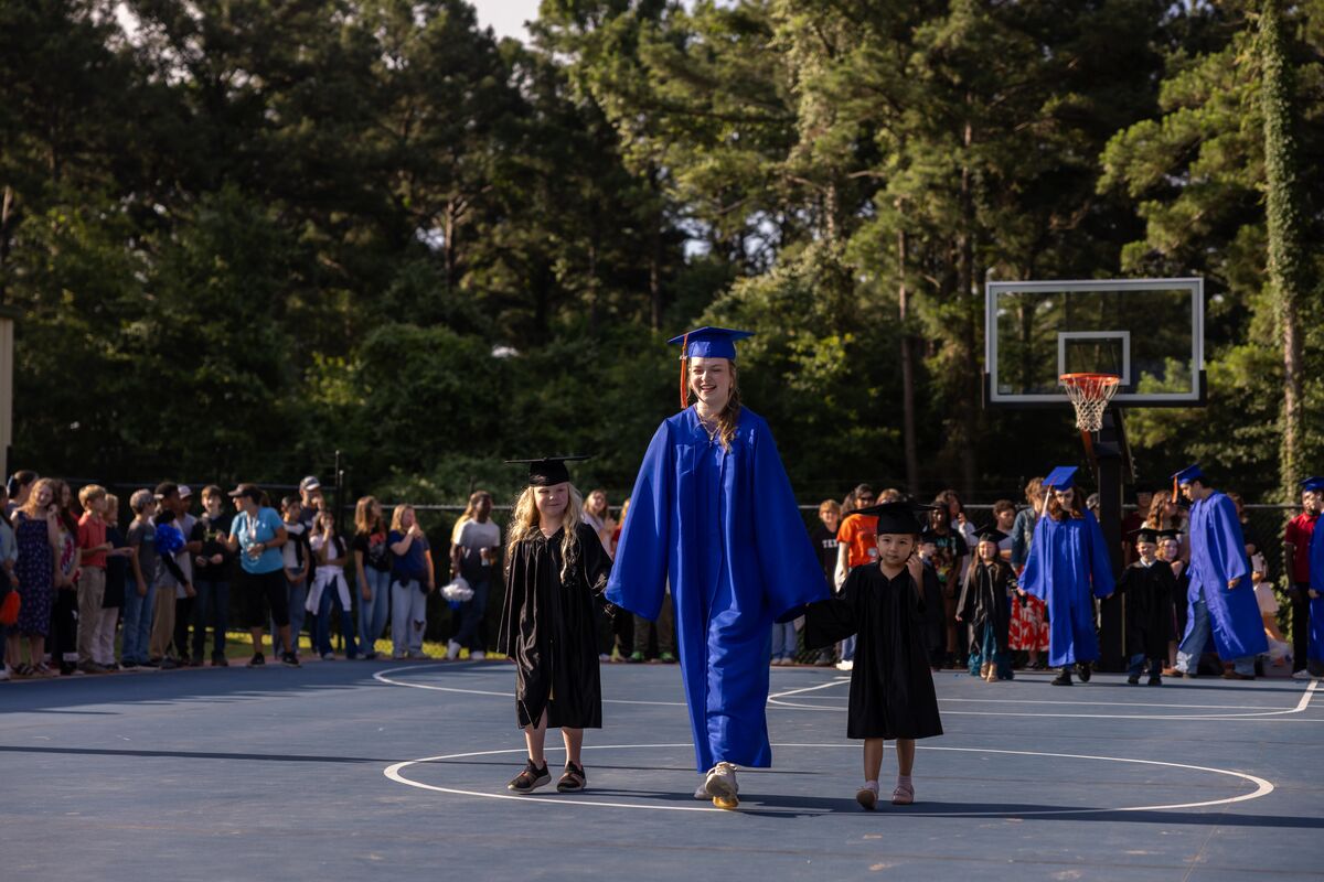 kinder and senior in cap and gown