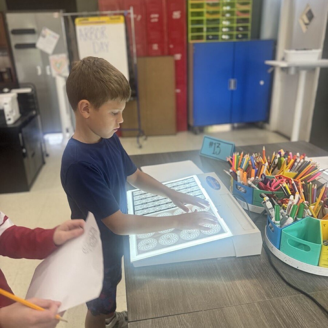 student using light board in art